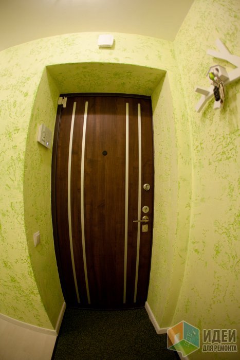 Дизайн длинного коридора салатового цвета с декоративной штукатуркой на стенах и мини-гардеробной
