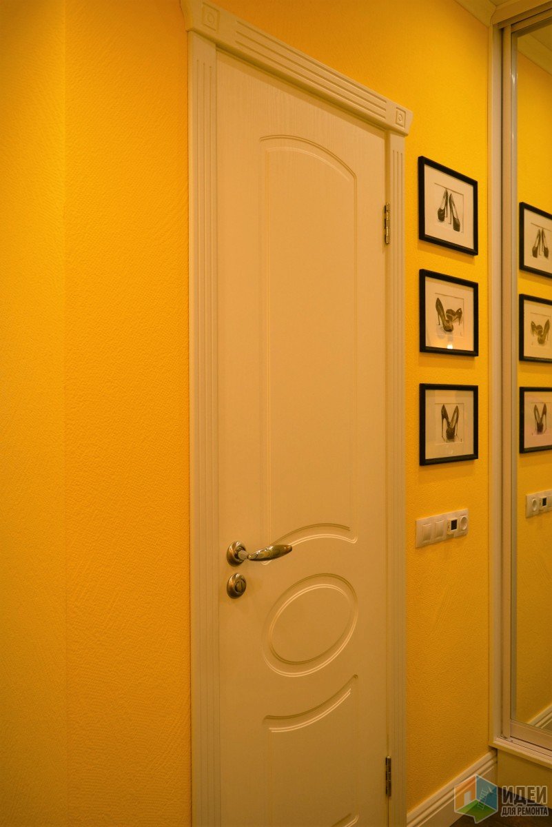 Маленькая желтая прихожая с зеркальным шкафом-купе, тумбой и оригинальными лампами Эдиссона