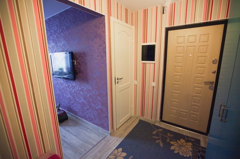 Дизайн вытянутого коридора с полосатыми обоями на стенах и серыми распашными шкафами (8 фото)