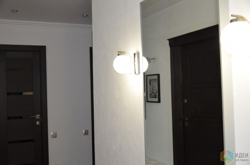 Белая Г-образная прихожая с декоративной штукатуркой на стенах и дверьми цвета венге